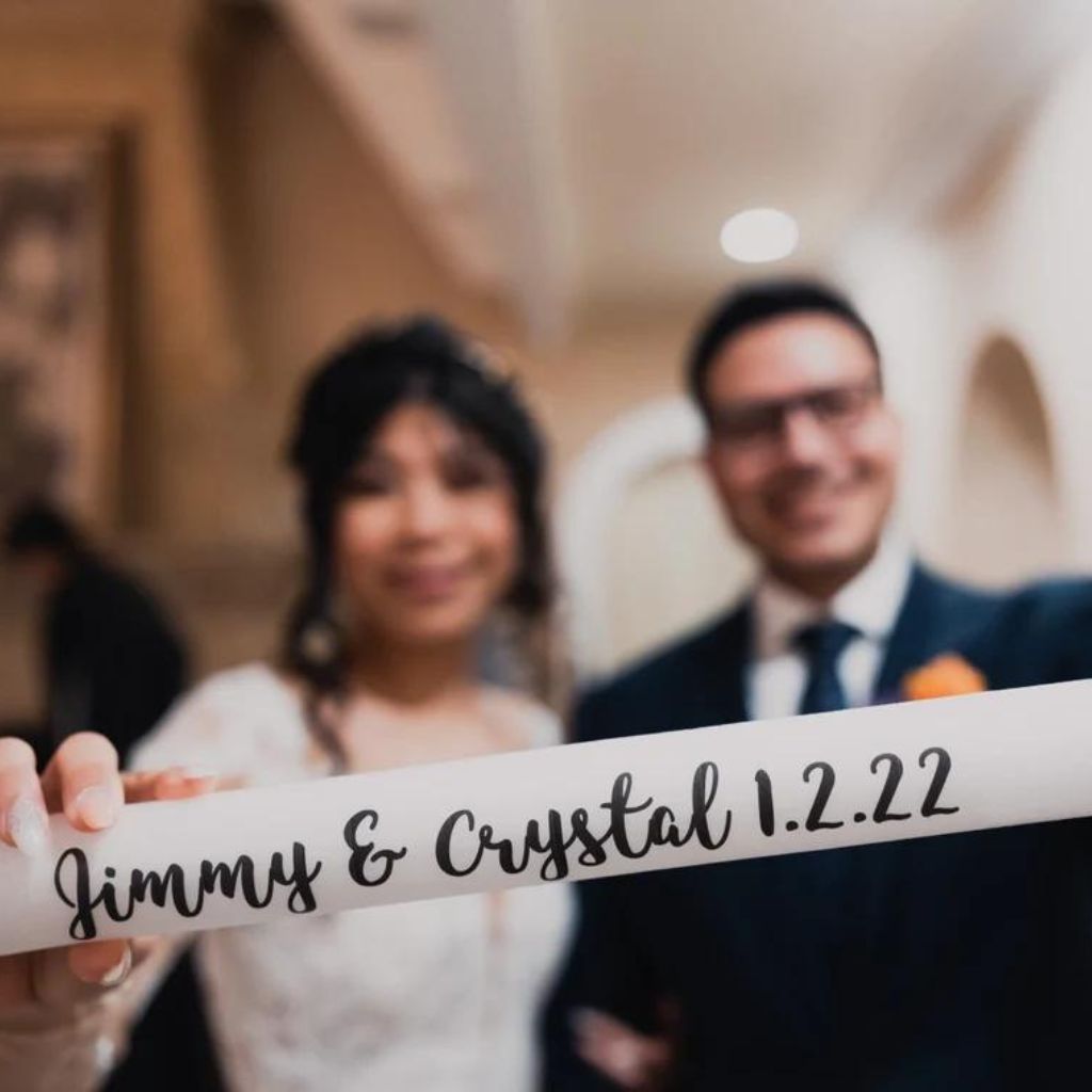 a bride and groom holding up a sign that says jimmy & crystal