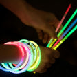 a person holding a bunch of glowing bracelets