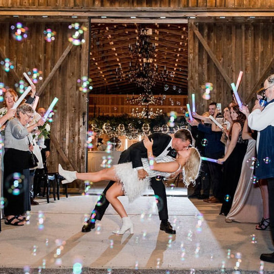 a bride and groom kissing in front of bubbles