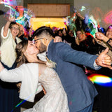 a bride and groom kissing in front of a crowd of people